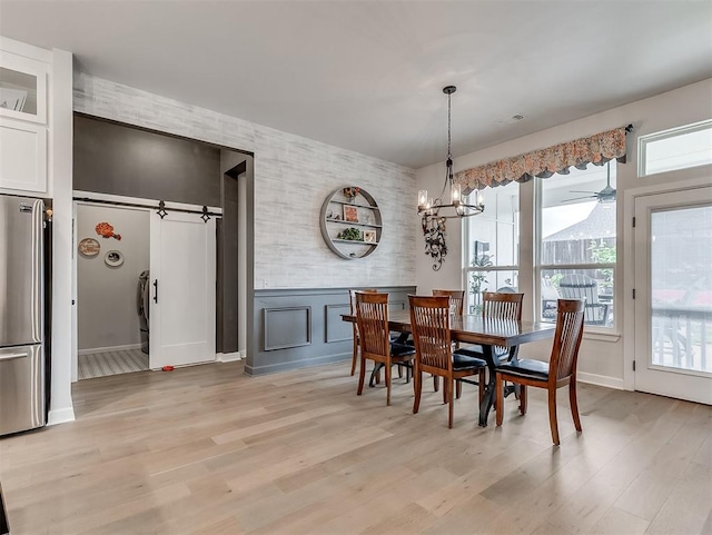 15936 Buffalo Dr, Oklahoma City, OK 73170 - dining space featuring a decorative wall, light wood-style floors, an accent wall, ceiling fan with notable chandelier, and visible vents