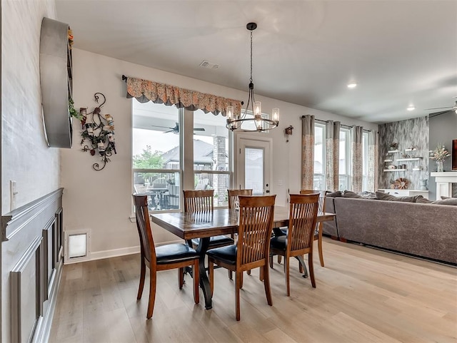 15936 Buffalo Dr, Oklahoma City, OK 73170 - dining space with light wood finished floors, ceiling fan with notable chandelier, visible vents, and a fireplace