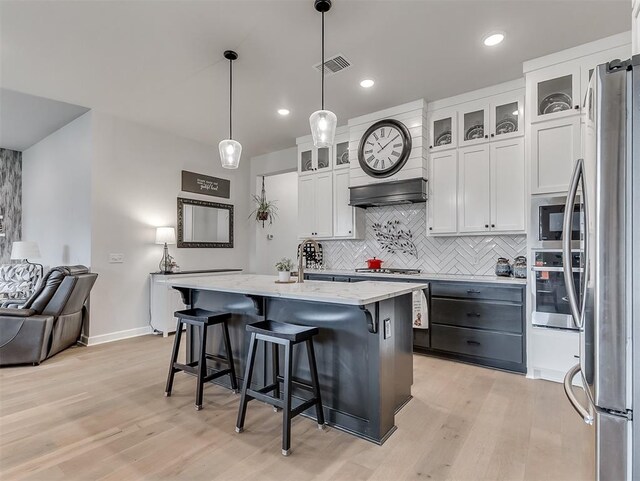 15936 Buffalo Dr, Oklahoma City, OK 73170 - kitchen with visible vents, stainless steel appliances, backsplash, and light wood finished floors