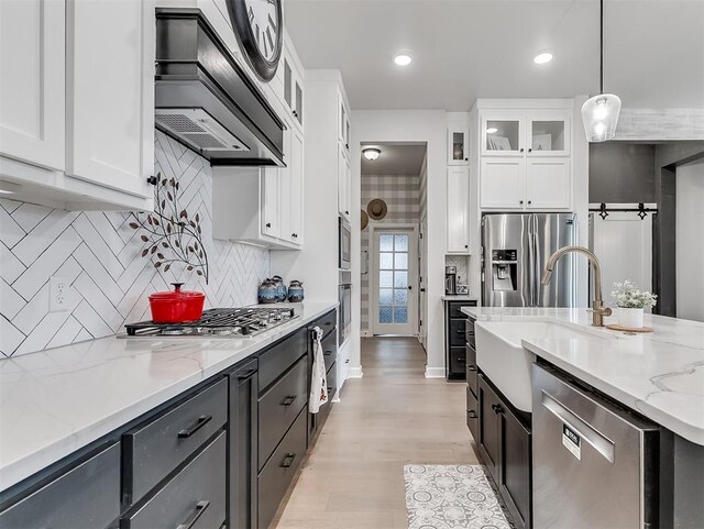 15936 Buffalo Dr, Oklahoma City, OK 73170 - kitchen featuring light stone countertops, stainless steel appliances, white cabinets, a sink, and premium range hood