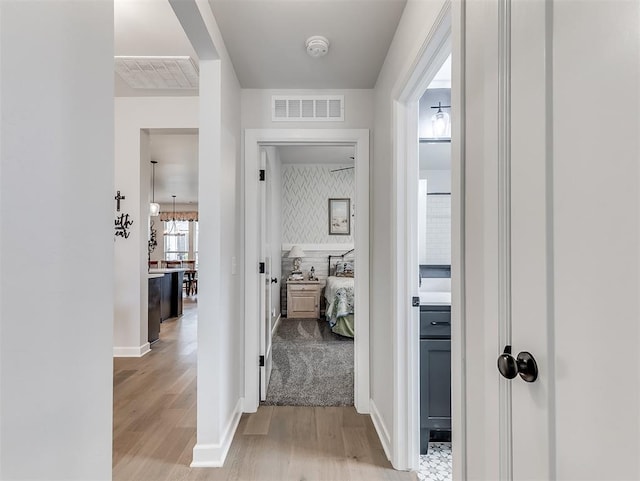 15936 Buffalo Dr, Oklahoma City, OK 73170 - hallway featuring baseboards, visible vents, and light wood-style floors