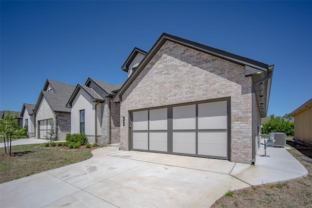2909 SW 132nd St, Oklahoma City, OK 73170 - view of front of home with an attached garage, driveway, central AC, and stone siding