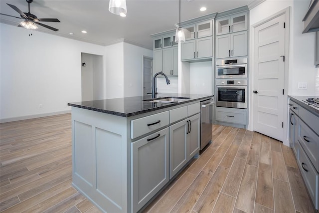 2909 SW 132nd St, Oklahoma City, OK 73170 - kitchen with light wood finished floors, stainless steel appliances, a ceiling fan, and a sink