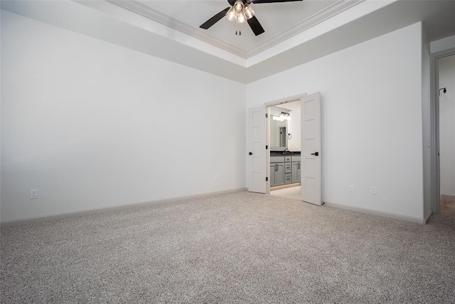 2909 SW 132nd St, Oklahoma City, OK 73170 - unfurnished bedroom featuring a tray ceiling, ornamental molding, light carpet, connected bathroom, and baseboards