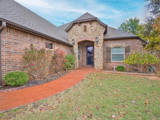 1832 Buckskin Ct, Blanchard, OK 73010 - french country style house featuring a shingled roof, brick siding, and a front yard