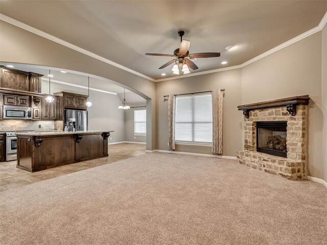 1832 Buckskin Ct, Blanchard, OK 73010 - unfurnished living room with arched walkways, a fireplace, and light colored carpet