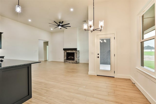 kitchen with a fireplace, decorative light fixtures, light wood finished floors, and a chandelier