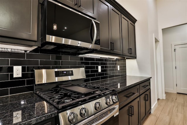 kitchen with tasteful backsplash, dark brown cabinets, baseboards, dark stone counters, and stainless steel appliances