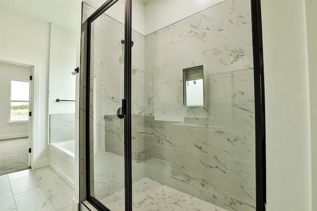 full bathroom featuring baseboards, a shower stall, a bath, and marble finish floor