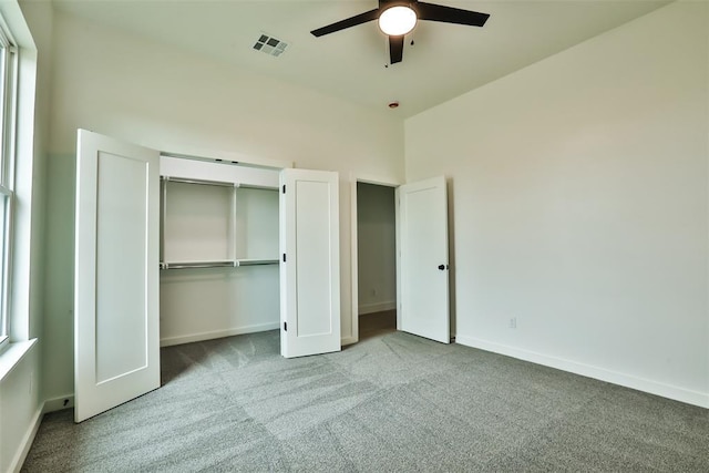 unfurnished bedroom featuring ceiling fan, carpet floors, baseboards, visible vents, and a closet