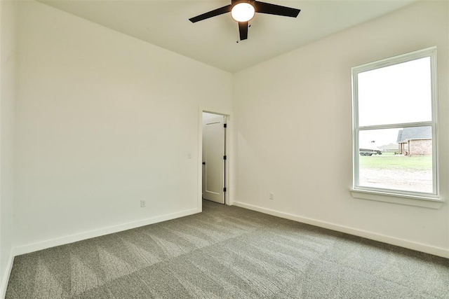 spare room featuring carpet floors, a ceiling fan, and baseboards