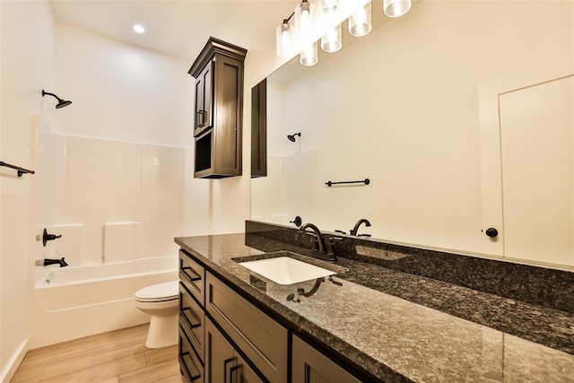 bathroom featuring vanity, bathtub / shower combination, toilet, and wood finished floors
