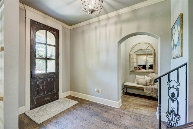 foyer with baseboards, ornamental molding, and wood finished floors
