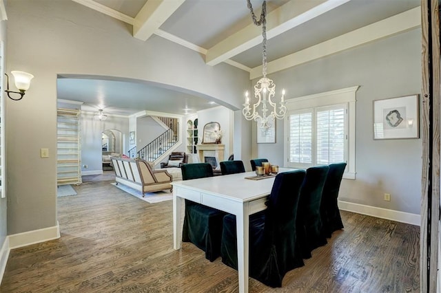 dining room featuring beam ceiling, arched walkways, ceiling fan with notable chandelier, baseboards, and wood finished floors