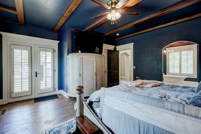 bedroom featuring access to outside, beam ceiling, arched walkways, baseboards, and wood finished floors