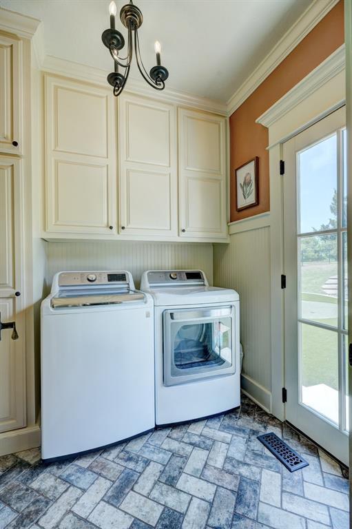 laundry area with independent washer and dryer, visible vents, cabinet space, a notable chandelier, and ornamental molding