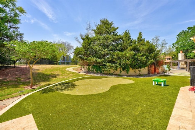 surrounding community featuring a trampoline and fence