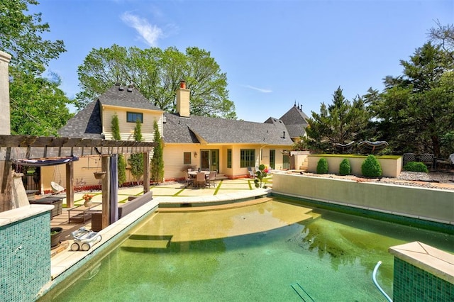 back of property with a chimney, a patio, fence, a pergola, and a shingled roof