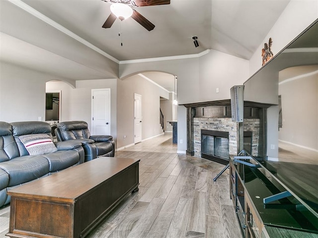 13612 Calabria Trl, Oklahoma City, OK 73170 - living area with vaulted ceiling, a ceiling fan, a stone fireplace, arched walkways, and baseboards