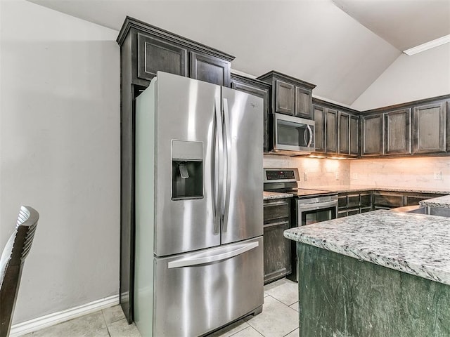 13612 Calabria Trl, Oklahoma City, OK 73170 - kitchen with light tile patterned flooring, vaulted ceiling, decorative backsplash, and stainless steel appliances