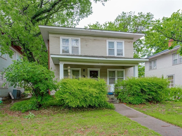 traditional style home featuring a front lawn and covered porch
