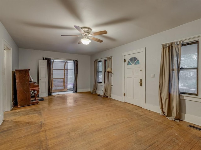 foyer entrance with baseboards, ceiling fan, light wood-style flooring, and visible vents