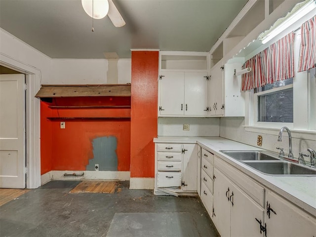 kitchen with a sink, white cabinetry, concrete floors, and light countertops