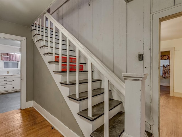staircase featuring baseboards and wood finished floors