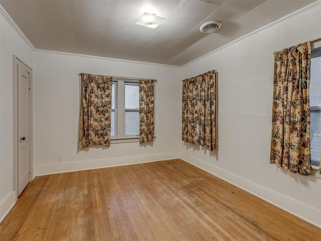 empty room with baseboards, light wood-type flooring, and visible vents