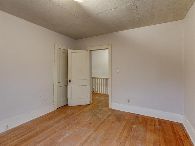 empty room featuring baseboards and light wood-style flooring
