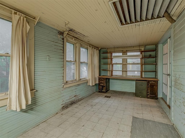 unfurnished sunroom with built in study area and a wealth of natural light