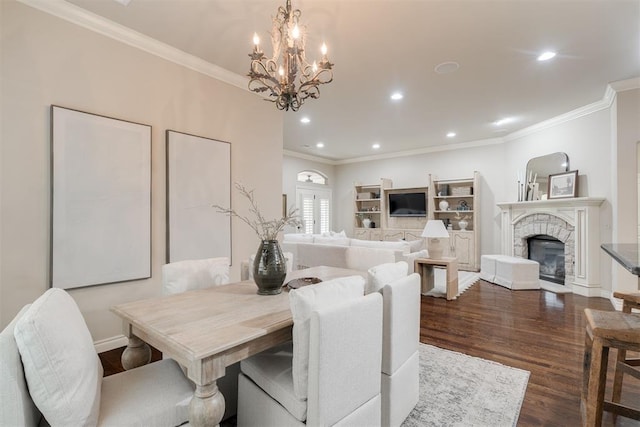 dining area featuring dark wood finished floors, recessed lighting, an inviting chandelier, a fireplace, and crown molding