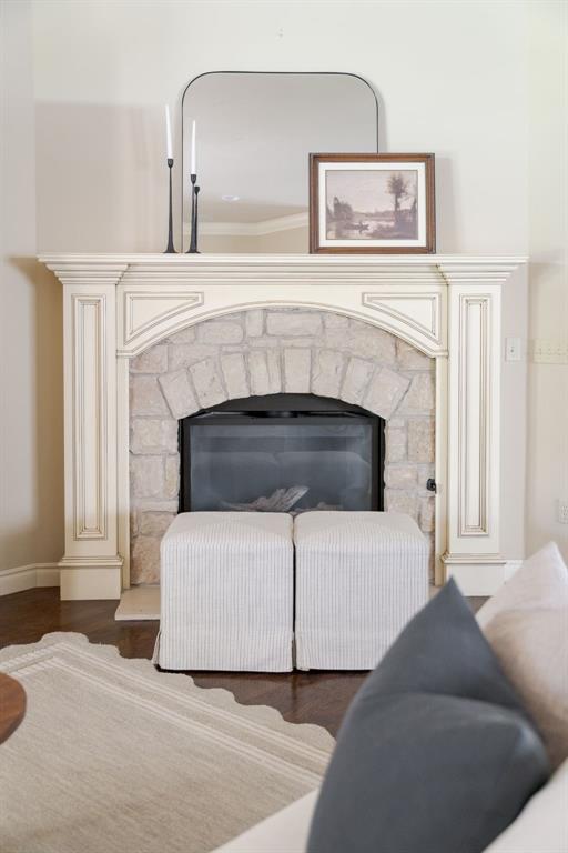 interior details with a fireplace, wood finished floors, and baseboards