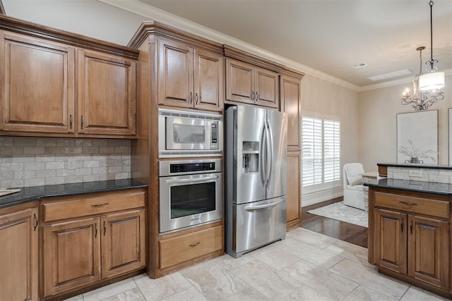 kitchen featuring decorative backsplash, a chandelier, stainless steel appliances, ornamental molding, and brown cabinetry