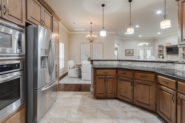 kitchen featuring stainless steel appliances, a wealth of natural light, ornamental molding, and arched walkways