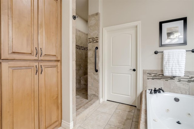 bathroom with a tub with jets, tiled shower, and tile patterned flooring