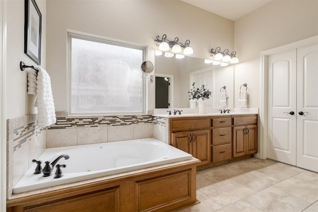 bathroom with double vanity, tile patterned flooring, a bath, and a sink