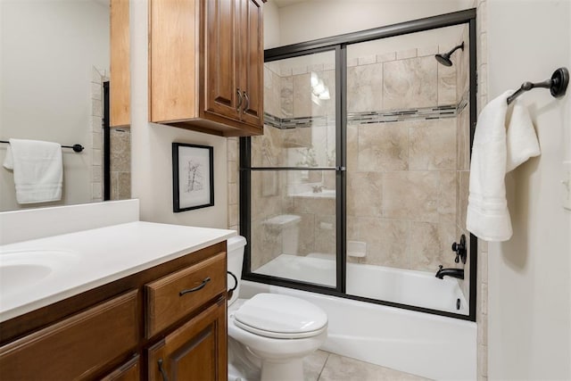 full bathroom featuring tile patterned floors, toilet, vanity, and shower / bath combination with glass door