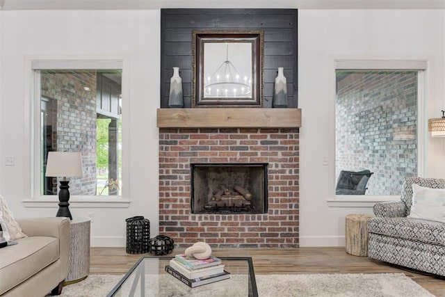 living room featuring baseboards, wood finished floors, and a fireplace