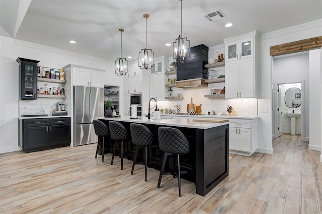 kitchen featuring a chandelier, stainless steel appliances, open shelves, visible vents, and light countertops