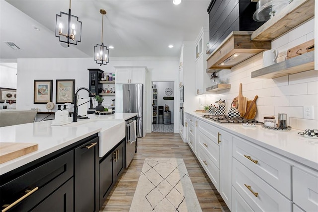 kitchen featuring a sink, stainless steel appliances, open shelves, white cabinetry, and light countertops