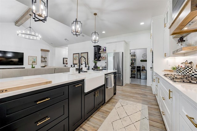 kitchen featuring an inviting chandelier, a sink, appliances with stainless steel finishes, and open shelves