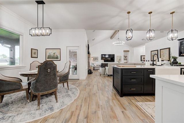 kitchen featuring a chandelier, light wood-style floors, lofted ceiling with beams, dark cabinetry, and light countertops