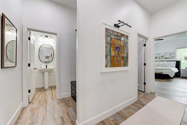 hall featuring baseboards and light wood-type flooring