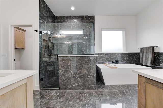 bathroom featuring a soaking tub, a marble finish shower, recessed lighting, vanity, and marble finish floor