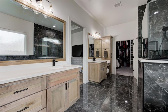 full bath with a sink, a shower stall, marble finish floor, visible vents, and a walk in closet