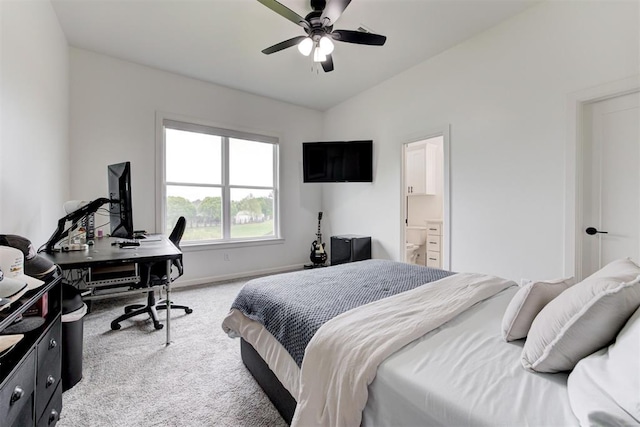 bedroom featuring ensuite bath, a ceiling fan, light carpet, baseboards, and lofted ceiling