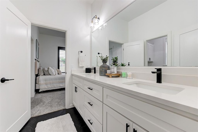 ensuite bathroom with tile patterned floors, ensuite bath, double vanity, and a sink