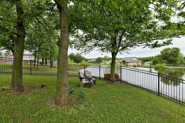 view of yard with a fenced backyard and a water view