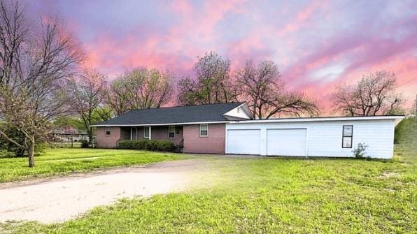 view of front of house with a front yard, an attached garage, and driveway